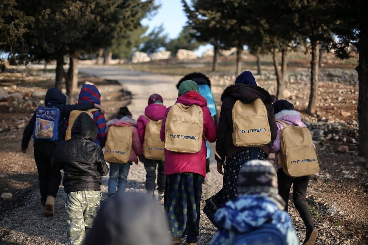 Children walking with Pay it forward backpacks